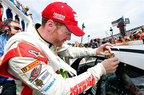Dale Earnhardt Jr putting winning sticker on race car at pocono